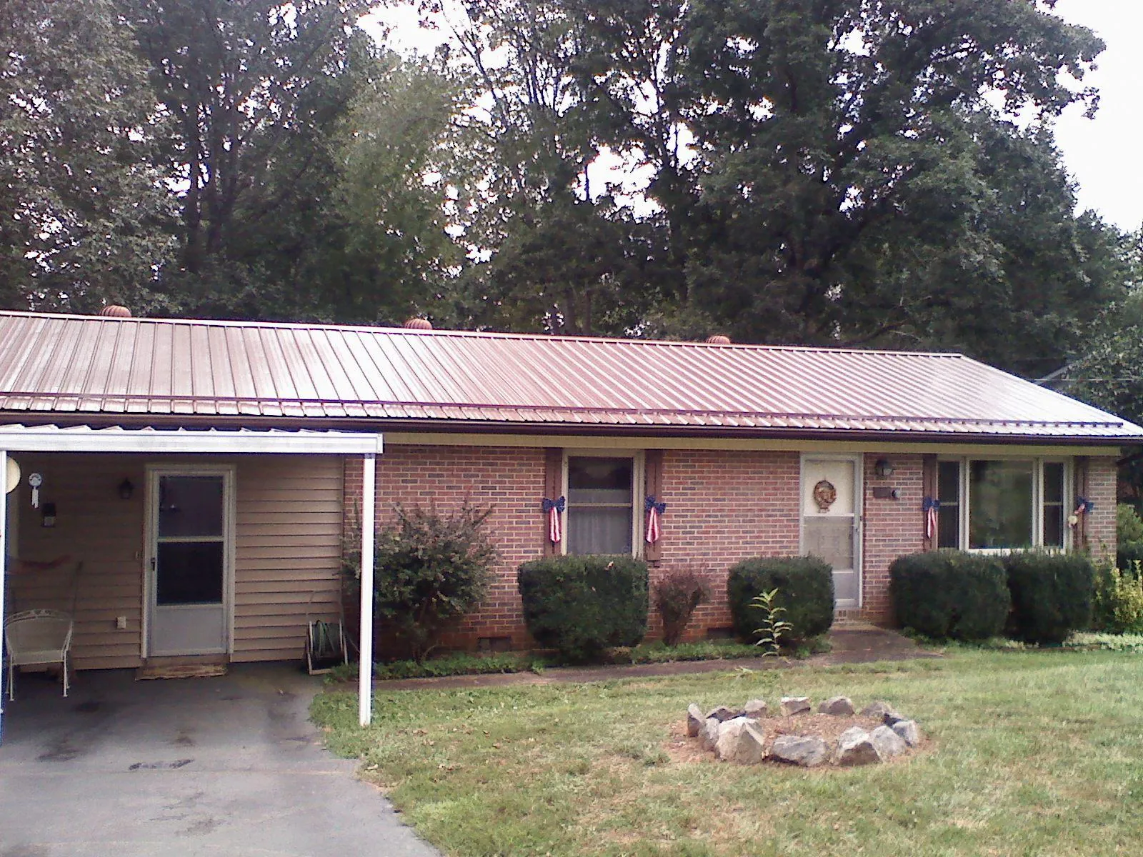 Bronze metal roof and carport on a brick ranch home — Roof Repair work by our crew in Hardin